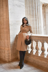 a lady wears a classic trench coat with a white shirt